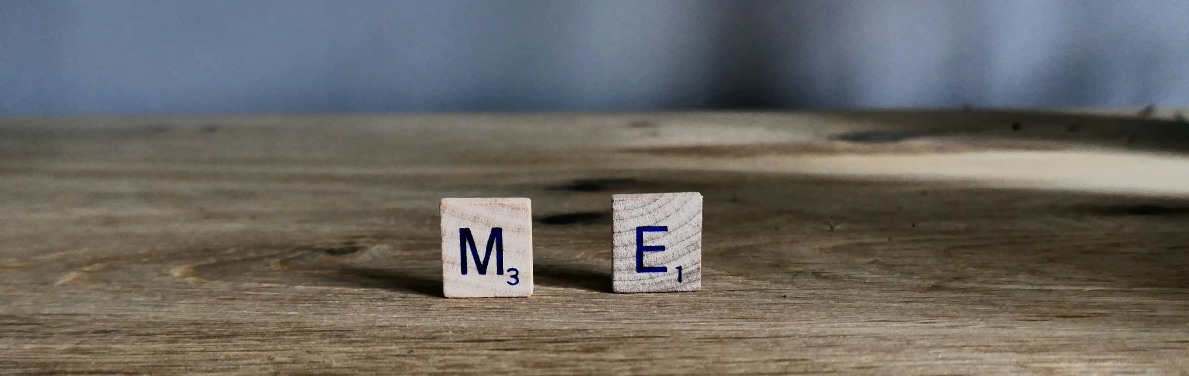 Wooden letter tiles spelling ME on a table